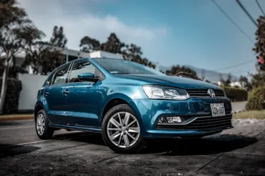 Niebieski Volkswagen Polo zaparkowany na ulicy.